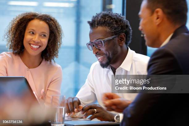 business people interacting and laughing during a meeting - free trade agreement stockfoto's en -beelden