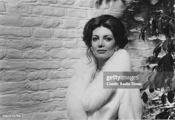 Portrait of actress Gayle Hunnicutt wearing a fur trimmed coat and standing in front of a brick wall, March 1974.