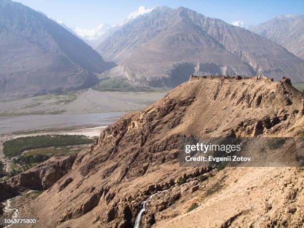 ruins of yamchun fort on tajik part of the wakhan valley with the hindu kush mountains on the background - badakhshan stock pictures, royalty-free photos & images