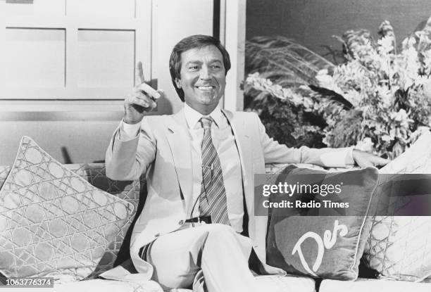 Portrait of comedian and television personality Des O'Connor sitting on a sofa, September 1981.