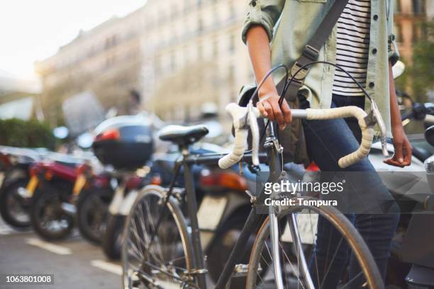 junge hipster frau in den straßen von barcelona zu pendeln. - commuter man europe bike stock-fotos und bilder