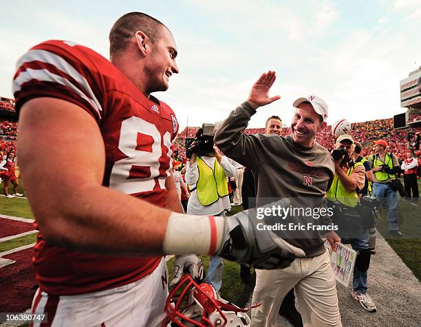 Coach Bo Pelini of the Nebraska Cornhuskers high fives tight end Ben Cotton after their game against the Missouri Tigers at Memorial Stadium on...