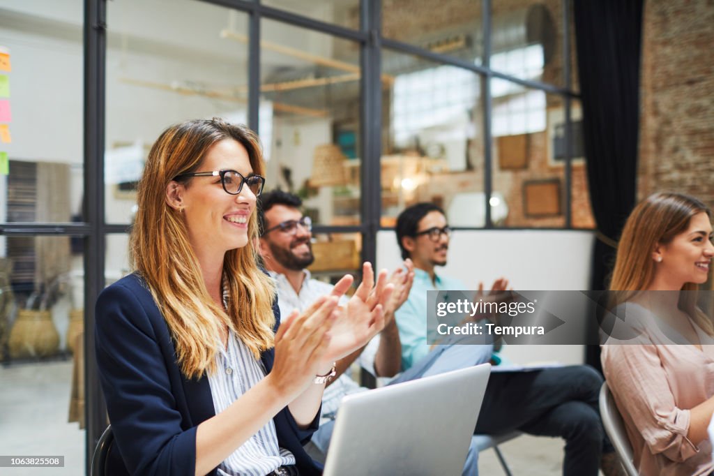 Group of people listening to a presentation speech.