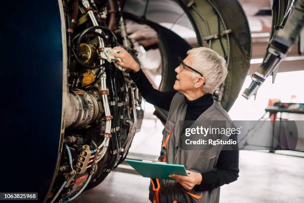 female mechanic repairing aircraft - old woman mechanic stock pictures, royalty-free photos & images
