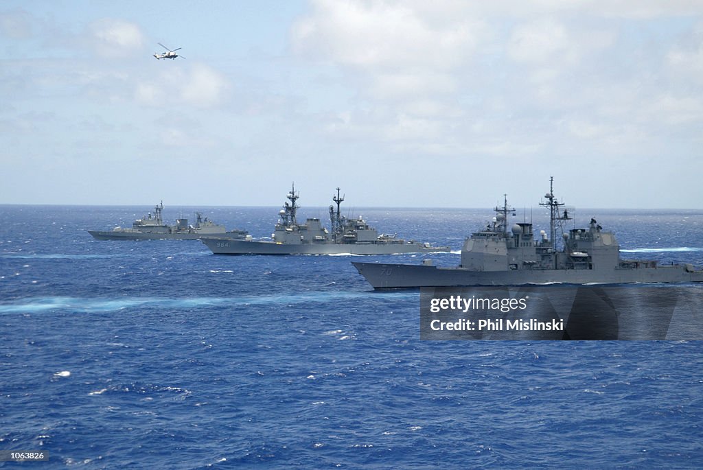 Operation Rimpac Naval ships from multiple nations steam in formation while a UH-3H ...