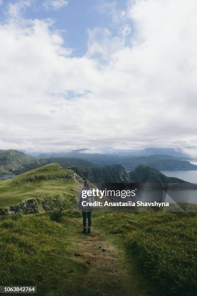 vrouw met rugzak wandelen op runde eiland in noorwegen - midnight sun norway stockfoto's en -beelden