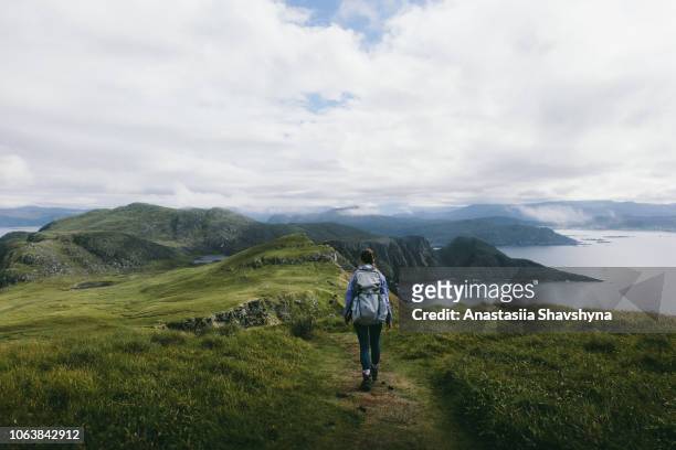 woman with backpack hiking on runde island in norway - hiking backpack stock pictures, royalty-free photos & images