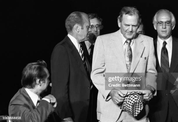 President Jerry Ford and Alabama head football coach Paul "Bear" Bryant share a chuckle as the president checks out the coaches famed checkered hat....