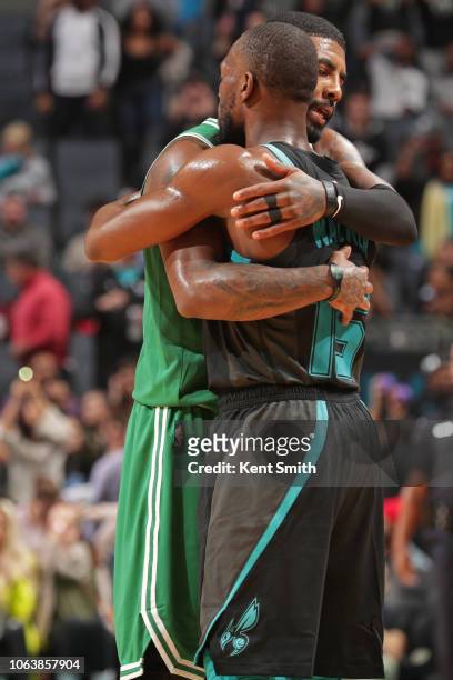 Kyrie Irving of the Boston Celtics hug Kemba Walker of the Charlotte Hornets on November 19, 2018 at Spectrum Center in Charlotte, North Carolina....