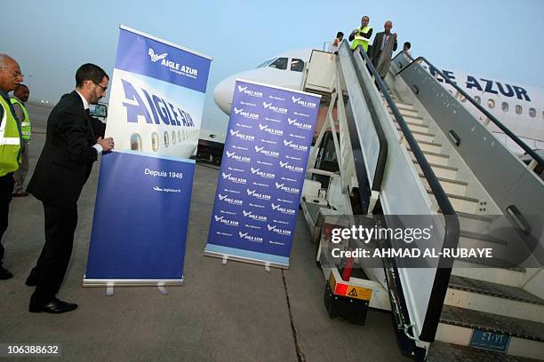 Airport staff wait for the passengers to disembark off an Airbus A319 plane operated by France's Aigle Azur at Baghdad's International Airport on...