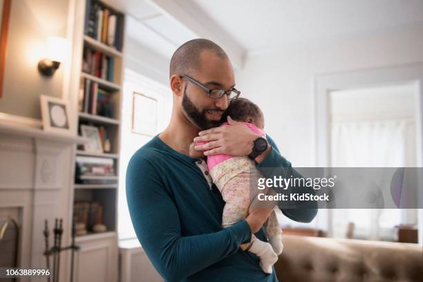 Hispanic father holding newborn baby girl
