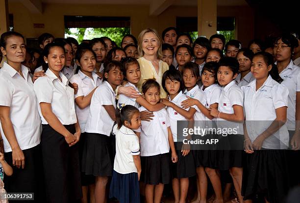 Secretary of State Hillary Rodham Clinton posses with children during a tour of the Siem Reap Center, a shelter run by AFSEIP that provides...