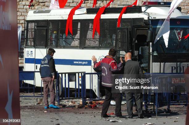 Turkish police and security forces look at the remains of a suicide bomber as they seal off Taksim Square, in the aftermath of a suicide attack which...