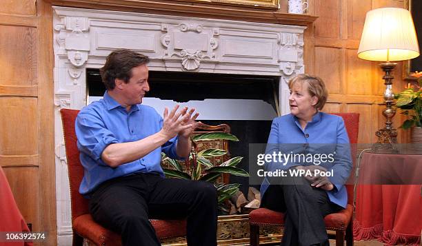 British Prime Minister David Cameron speaks with German Chancellor Angela Merkel at Chequers, the Prime Minister's country residence on October 31,...