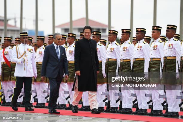 Pakistan's Prime Minister Imran Khan is accompanied by his Malaysian counterpart Mahathir Mohamad as he reviews a guard of honour during a welcoming...