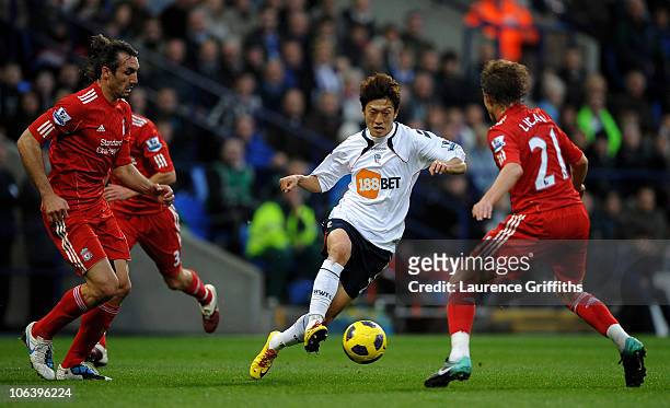 Chung Yong Lee of Bolton Wanderers looks for a way past the challenge of Lucas of Liverpool during the Barclays Premier League match between Bolton...