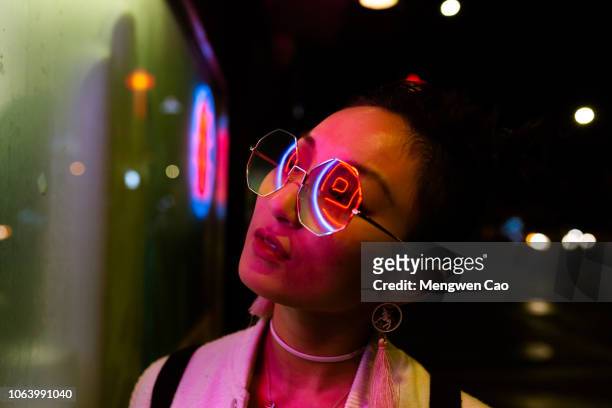 portrait of young woman under neon light - bright lights big city visions of new york at night stockfoto's en -beelden