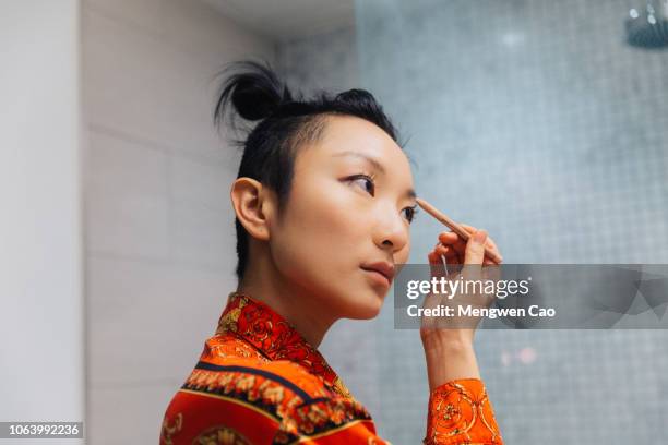 young woman doing makeup - showus ストックフォトと画像