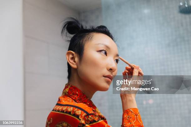 young woman doing makeup - showus stock pictures, royalty-free photos & images