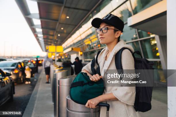 young woman waiting outside the airport - new york personas stock-fotos und bilder