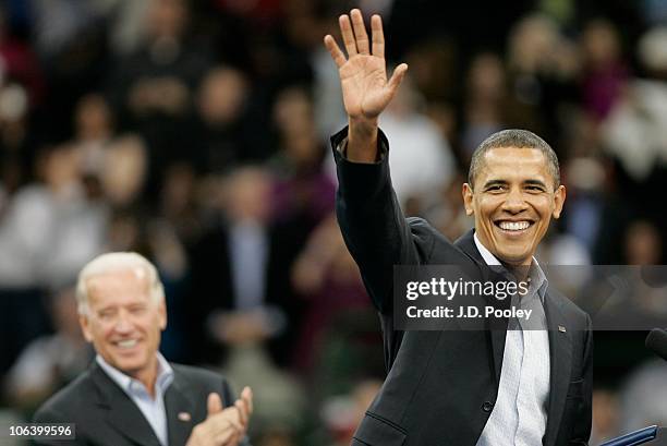 President Barack Obama waves to supporters while U.S. Vice President Joe Biden looks on during the president's 'Moving America Forward' rally October...