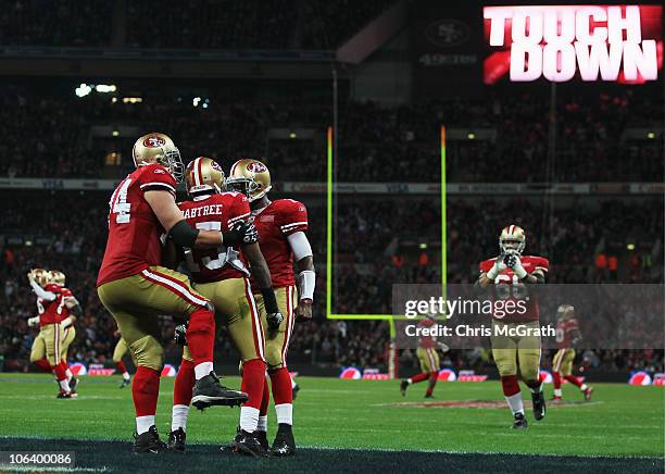 Michael Crabtree of San Francisco 49ers is congratulated by team mates as he scores their second touchdown during the NFL International Series match...