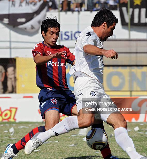 Argentine Juan Carlos Ferreyra of Olimpia, struggles for the ball with Fidel Amado Perez of Cerro Porteno, during the Paraguayan derby on October 31,...