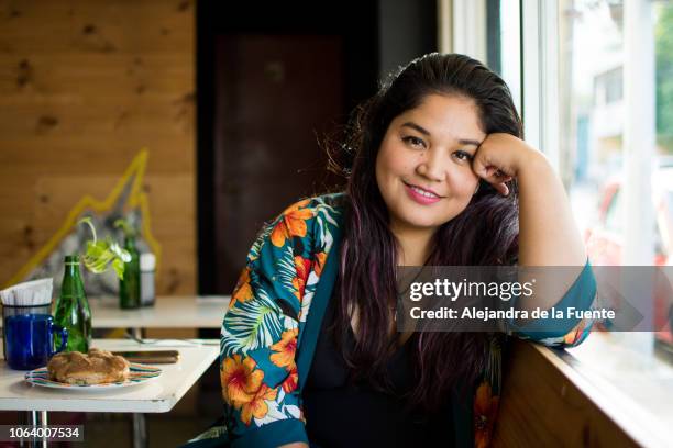 portrait of a young latina woman sitting at a restaurant - persona de color 個照片及圖片檔