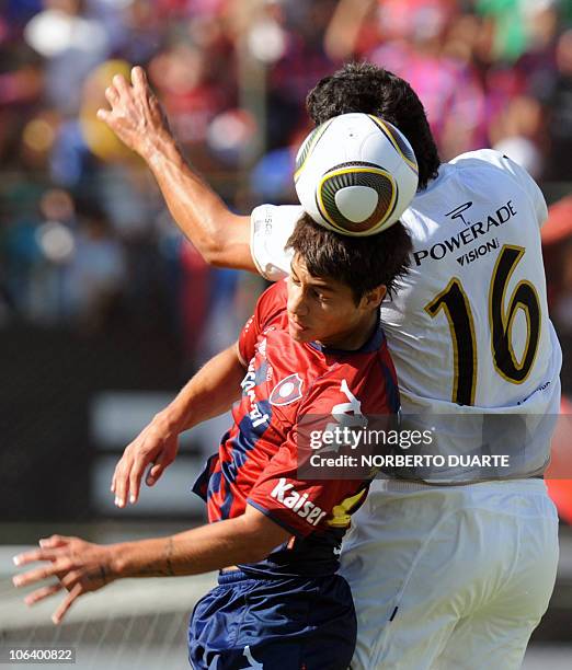 Argentine Juan Carlos Ferreyra of Olimpia struggles for the ball with Fidel Amado Perez of Cerro Porteno during the Paraguayan derby on October 31,...