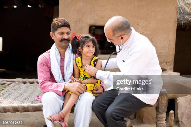 kinderarzt arzt untersuchen kranke mädchen im dorf - indian doctors stock-fotos und bilder