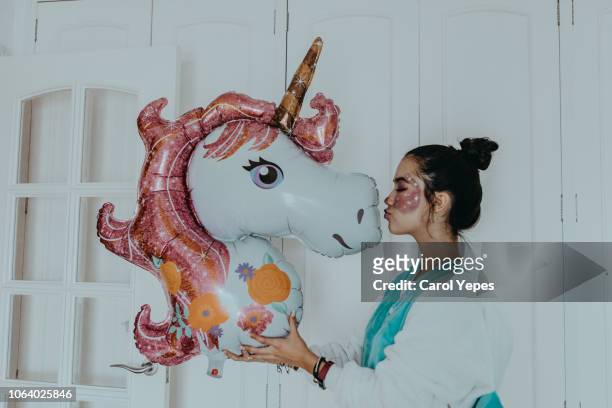 beautiful teenager kissing a unicorn balloon - unicorn stock pictures, royalty-free photos & images