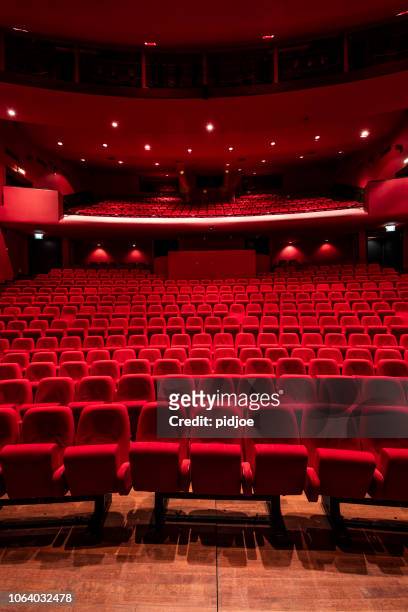 red seats in theather - film industry stock pictures, royalty-free photos & images