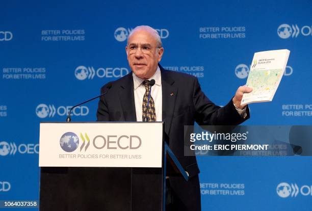 Secretary-General of the Organisation for Economic Co-operation and Development Jose Angel Gurria shows the latest economic outlook during a press...