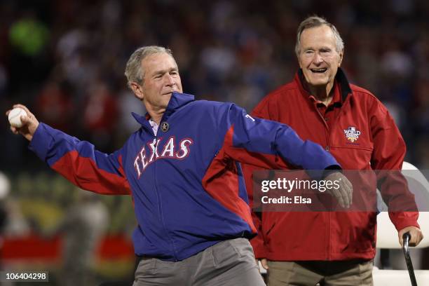 Former President of the United States, George W. Bush, throws out the first pitch as his father Former President George H.W. Bush looks on before the...