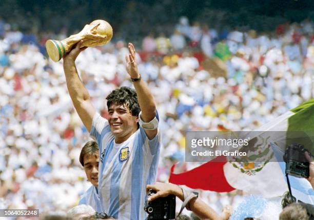Diego Maradona of Argentina holds the World Cup trophy after defeating West Germany 3-2 during the 1986 FIFA World Cup Final match at the Azteca...