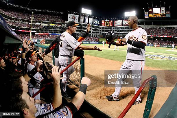 Manager Bruce Bochy of the San Francisco Giants congratulates Edgar Renteria after Renteria scored in the top of the seventh inning against the Texas...