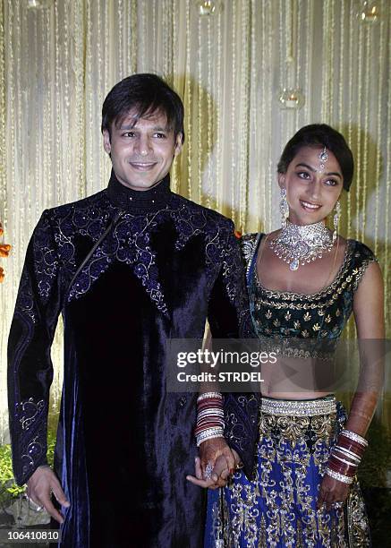 Indian Bollywood actor Vivek Oberoi recently married Priyanka Alva pose at a reception party late night October 31, 2010 in Mumbai. AFP PHOTO/STR