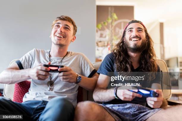 happy young male hipsters playing video game - hipsters fun indoor imagens e fotografias de stock