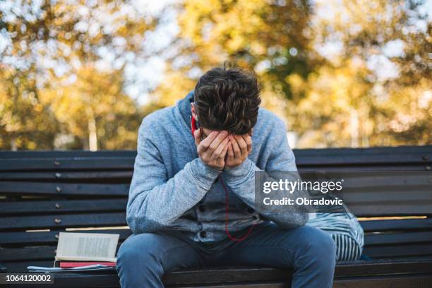 teenager has a headache because a lot of learning - male student stock pictures, royalty-free photos & images