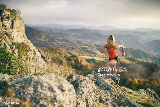 young woman running on mountain - correr imagens e fotografias de stock