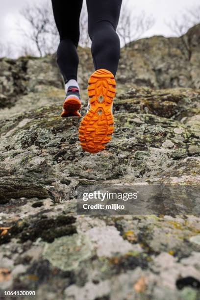 junge frau läuft am berg - schuhe für sport und freizeit stock-fotos und bilder