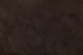 Dark brown matt suede fabric closeup. Velvet texture.