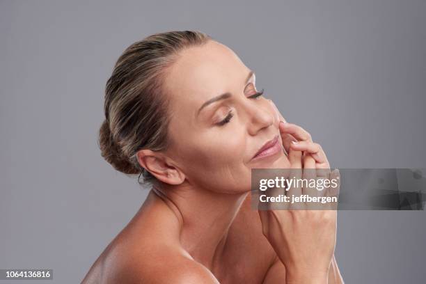 elle a obtenu que nous serions tous ravis d’avoir la peau lisse - woman hand face photos et images de collection