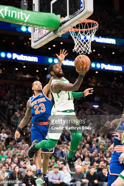 Kyrie Irving of the Boston Celtics drives past Trey Burke of the New York Knicks during a game at TD Garden on November 21, 2018 in Boston,...