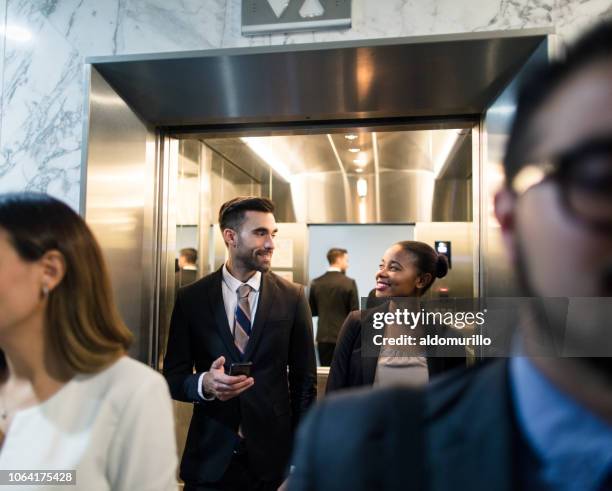 junge multi-ethnischen geschäftsleute zu fuß aus aufzug - elevator stock-fotos und bilder