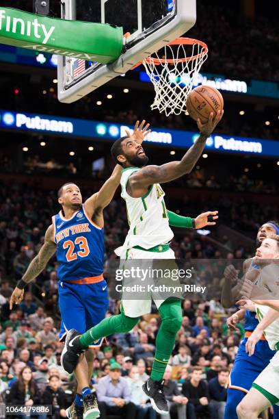 Kyrie Irving of the Boston Celtics drives past Trey Burke of the New York Knicks during a game at TD Garden on November 21, 2018 in Boston,...