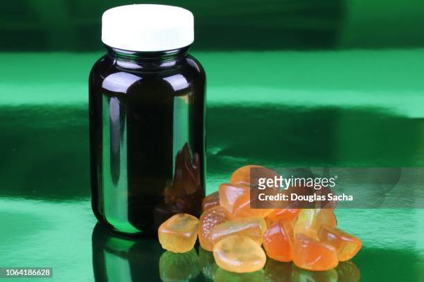 gummy pills and bottle - gummi stock pictures, royalty-free photos & images