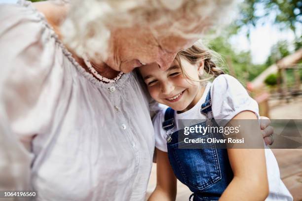 happy grandmother embracing granddaughter outdoors - grandmother bildbanksfoton och bilder