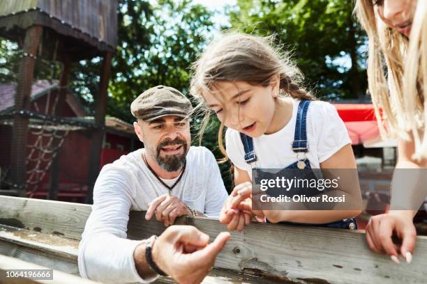 father with daughter at a water feature on a playground - curiosidad fotografías e imágenes de stock
