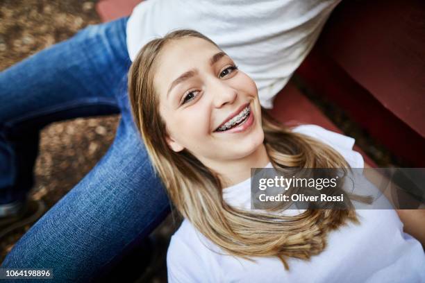 happy teenage daughter lying on father's lap on a bench - season 15 stock-fotos und bilder